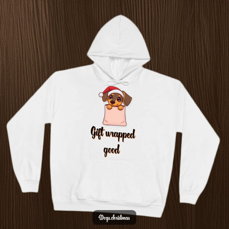 Funny Dachshund Hoodie: A dachshund wearing a Santa hat peeks from a gift bag, offering humorous holiday warmth and cuteness.