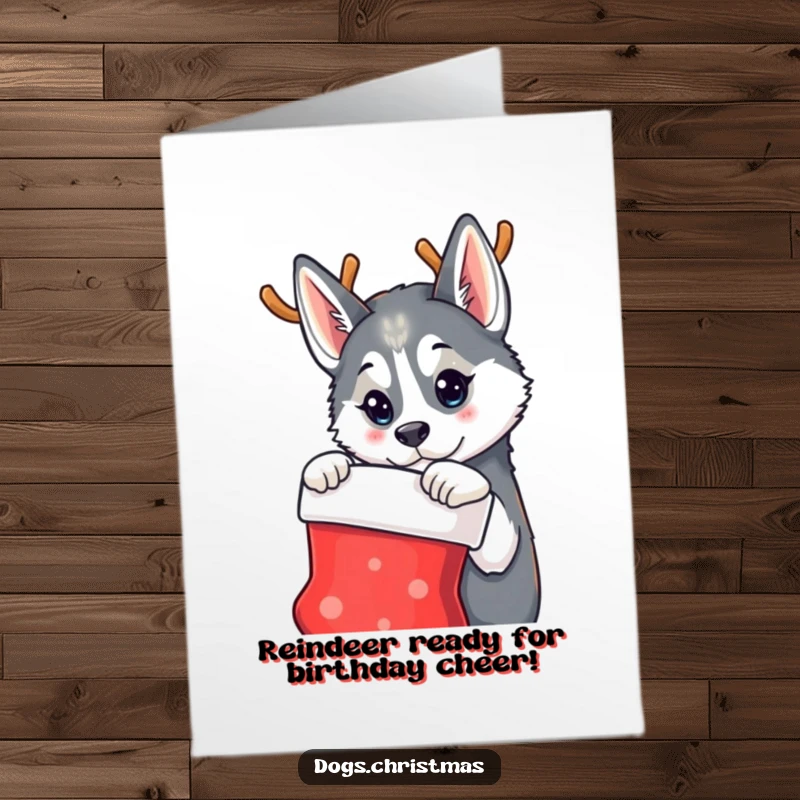 Funny Free Printable Birthday Card: A husky wearing reindeer antlers curiously gazes at a Christmas stocking, blending holidays and birthdays.