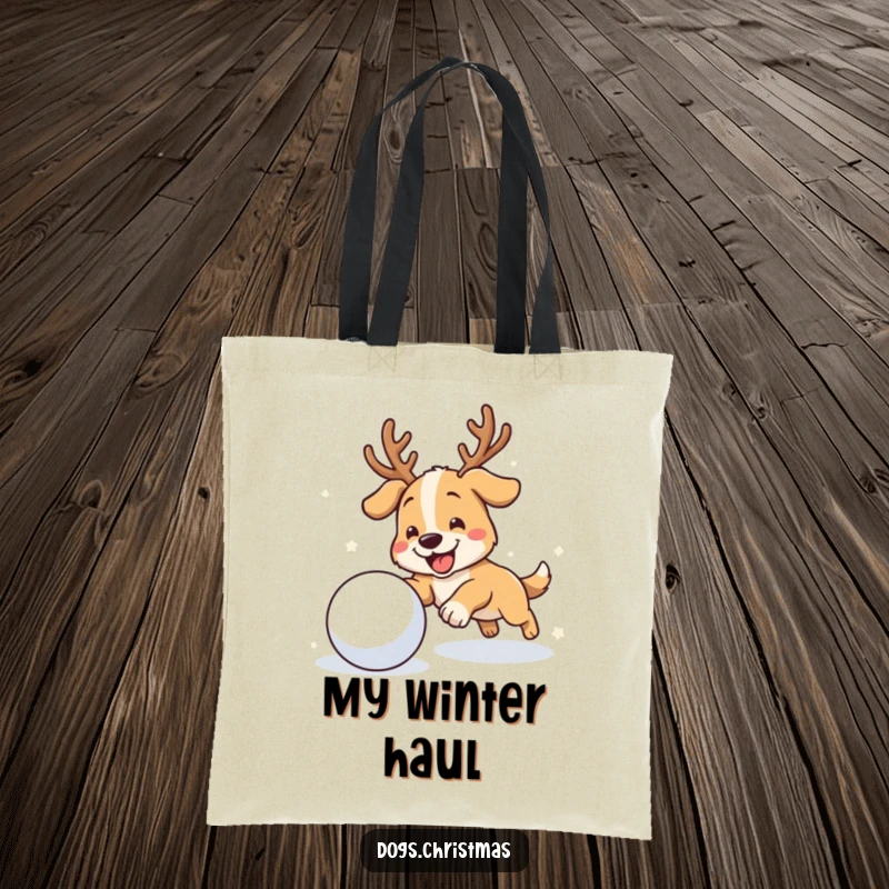 Funny antler dog tote bag featuring a dog with antlers joyfully chasing a snowball, perfect for carrying winter gear.